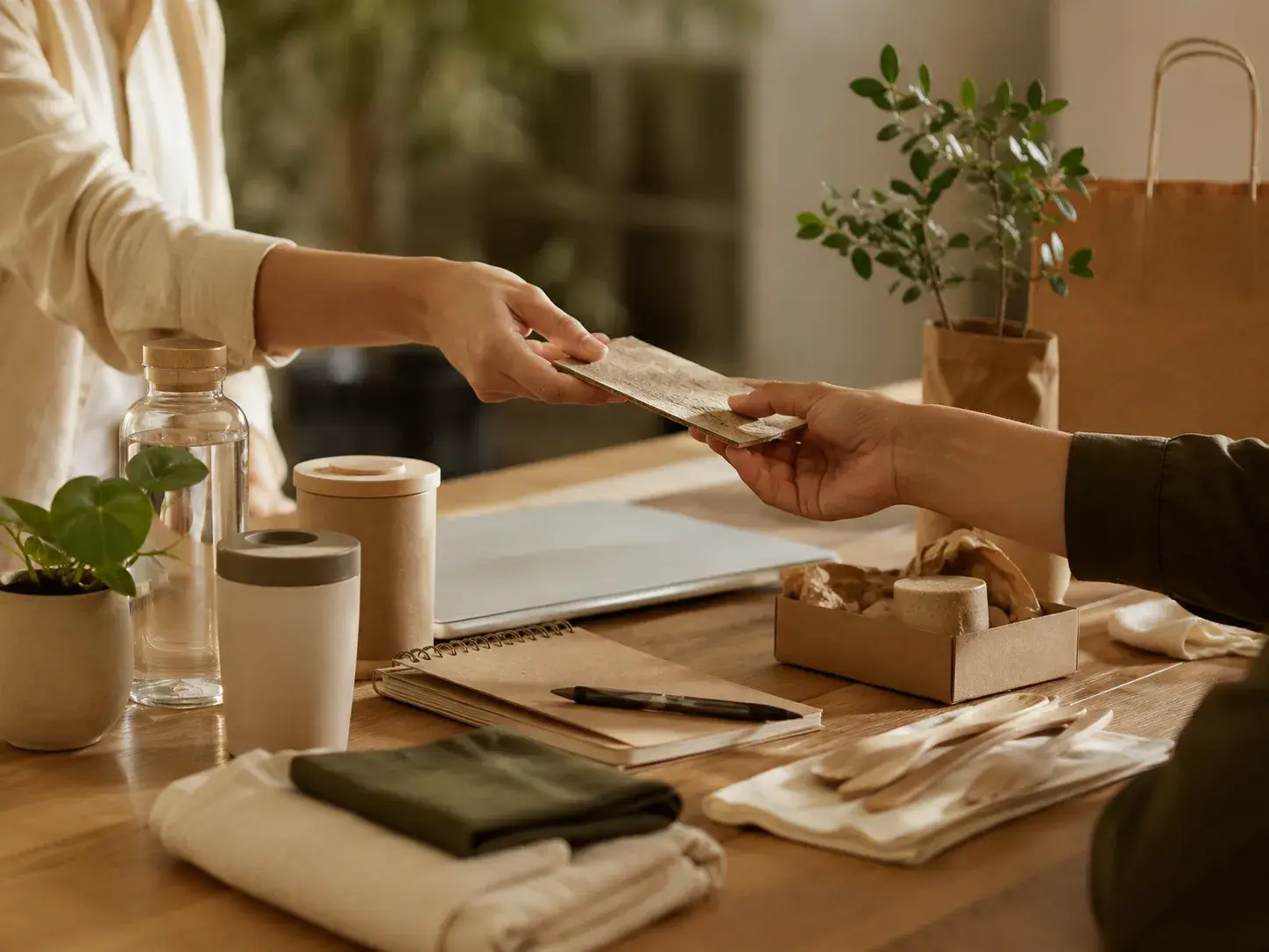 Twee professionals wisselen een duurzaam materiaalmonster uit aan een tafel met herbruikbare producten